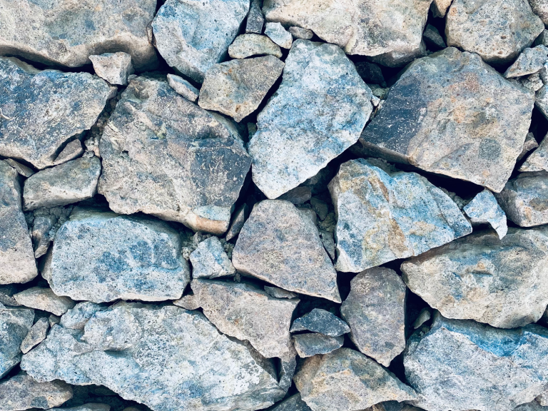 Grau-blaues Gestein in verschiedenen Größen, dicht aufeinanderliegend.
